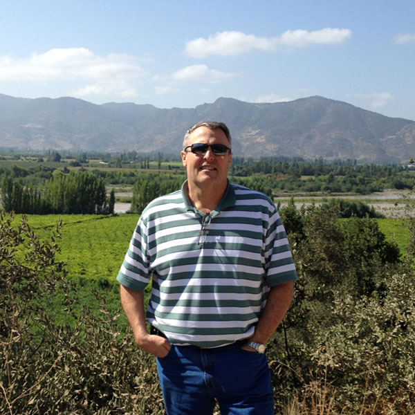 Mike Koehnen standing near a field with mountains in the background